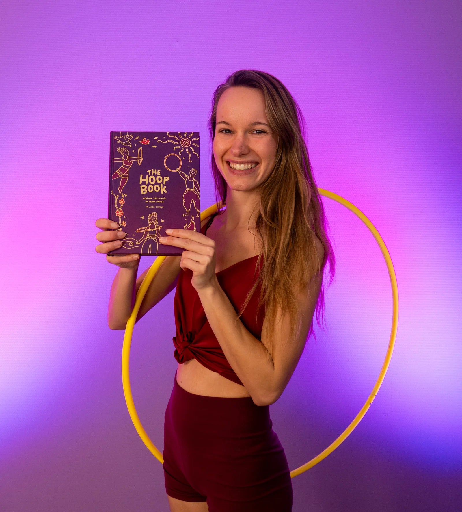 Author of The Hoop Book by Hoop Hoop Hurray smiling and holding the book, celebrating the art and joy of hoop dance.