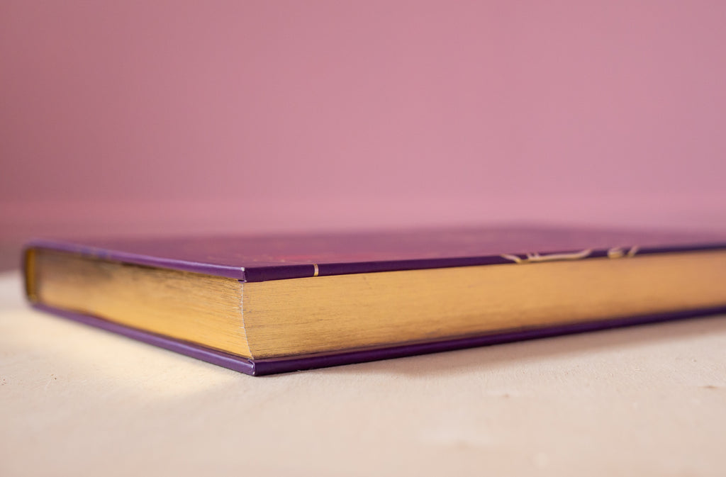 Closed copy of The Hoop Book by Hoop Hoop Hurray showing its gold-edged pages, symbolizing the creativity and beauty of hoop dance culture.